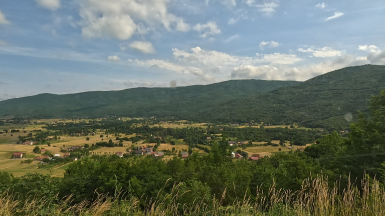 Uitzicht op de Gacka Dolina vallei met typisch witte huisjes tijdens Avonturen in Kroatië beginnen: gravel, storm en grotten. - theroamingrover.nl
