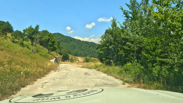 Abrupt einde van de weg langs de route naar Spomenik Sutjeska met begroeiing en afgrond