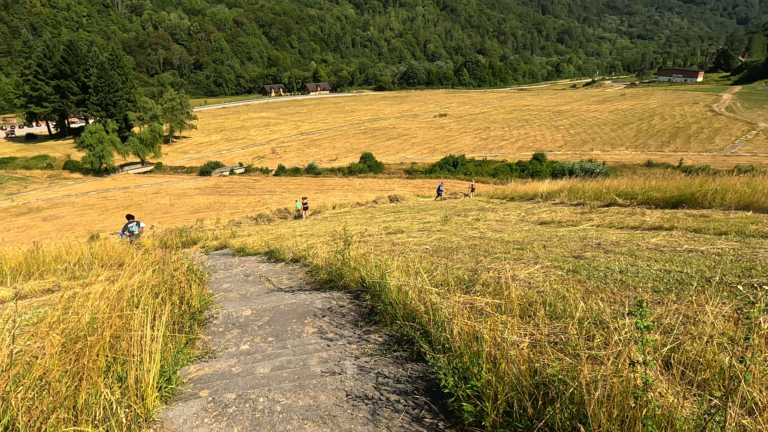Arbeiders die het gras maaien op de hellingen van het Spomenik Sutjeska monument