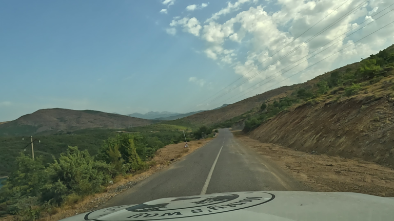 Smalle bergweg tussen hoge hellingen langs de SH25 in Noord-Albanië.