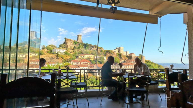Hotel/ Restaurant Panorama met uitzicht op stad Krujë en Krujë kasteel op bergtop.