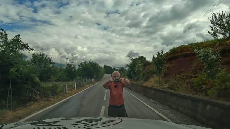 Ik houd een schildpad omhoog voor de gestopte camper, Monty, op de SH22.
