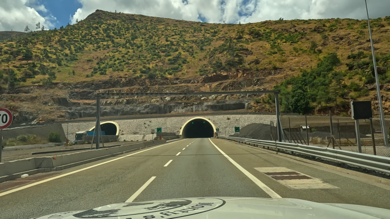 Rijdend richting een tunnel op de A1 snelweg in bergachtig Albanië.