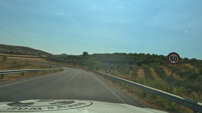 Olijfboomgaard langs tweebaansweg, SH3, (Albanië) met 60 km bord.