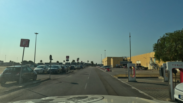 Vertrek vanaf P4N Brindisi met geparkeerde auto's, parkeerborden en gebouwen in het ochtendlicht