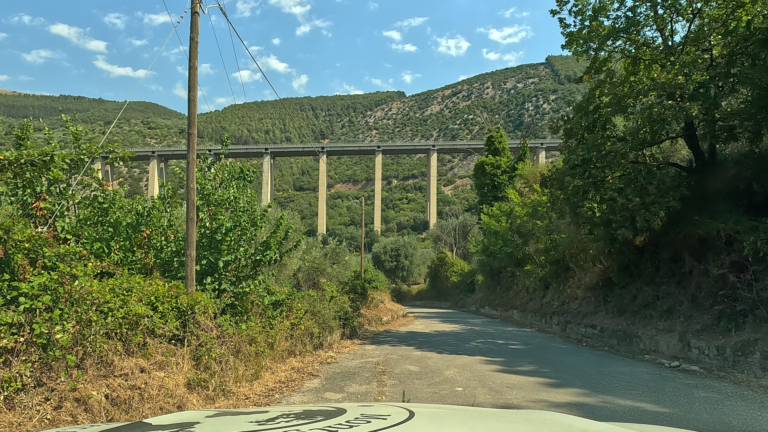 De route van Matera naar Laceno voert over een smalle weg met zicht op de enorme steunpilaren van de E847 boven de vallei.