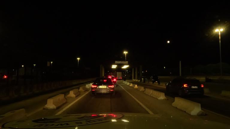 Twee rijen auto's rijden richting de douane na de bootovertocht van Griekenland naar Italië.