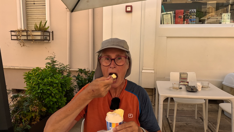 Ik eet aan een tafeltje een ijsje bij Gelateria Manfredo