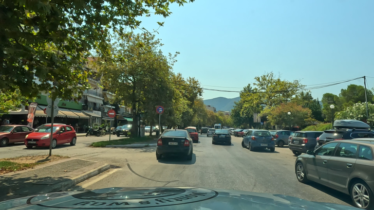 Monty rijdt over de E92 in Igoumenitsa tussen langzaam rijdende auto's richting de ferry.