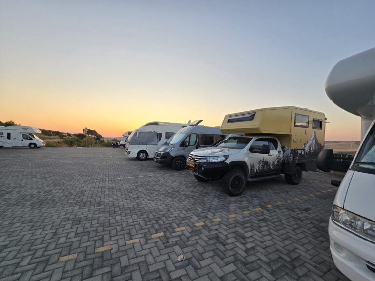 Tijdens mijn bezoek aan Matera staat camper Monty tussen andere campers op de camperplaats bij zonsondergang